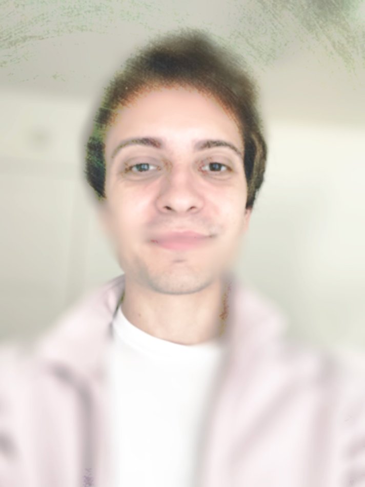 A photo of Paul, a low-vision white American man weaing a t-shirt and a tan jacket. The photo has been painted over and blurred with an iris blur, leaving the upper half of his face legible.